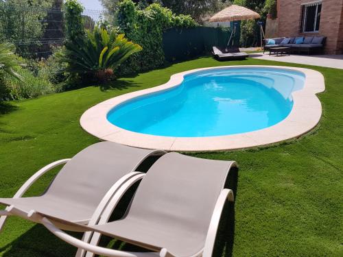 uma cadeira e uma piscina num quintal em Vivalavida playa 1km em Lloret de Mar