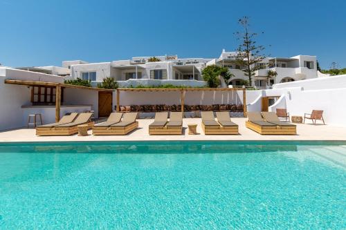 a group of lounge chairs next to a swimming pool at Cavos in Agios Sostis