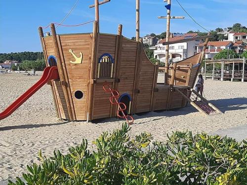 un parque infantil en la playa con un tobogán en Sandra -Lopar, en Lopar