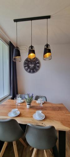 a wooden table with two chairs and two lights at FeWo Wanderlust in Altenau