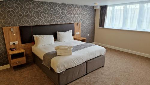 a bedroom with a bed with a teddy bear on it at Best Western Northfields Ealing Hotel in London