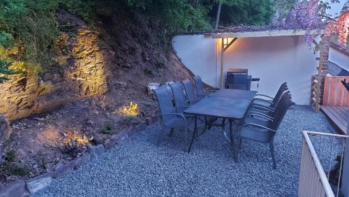 a table and chairs sitting next to a stone wall at Villa Bad Bertrich in Bad Bertrich