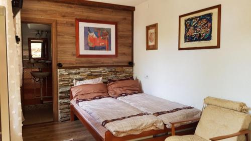 a bedroom with a bed and a stone wall at Restaurant and Apartments - T'ga za Jug Lazaropole in Lazaropole