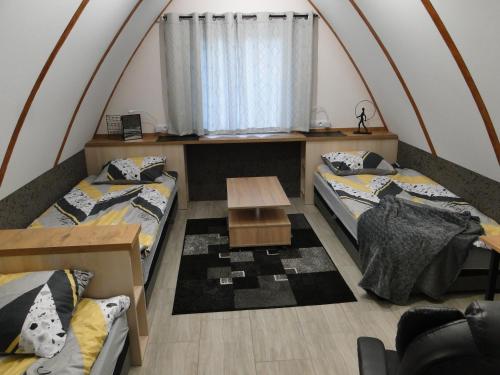 Habitación con 2 camas y mesa. en Cztery Pory Roku, en Gołdap