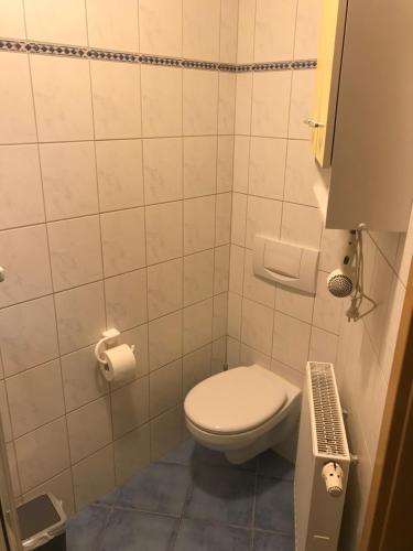 a bathroom with a toilet and a toilet paper dispenser at EZ im Haus Maja in Holzkirchen