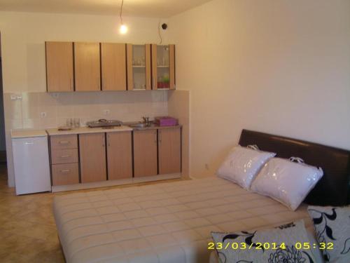 una camera con un letto e una piccola cucina di Apartmani Vukovic a Tivat