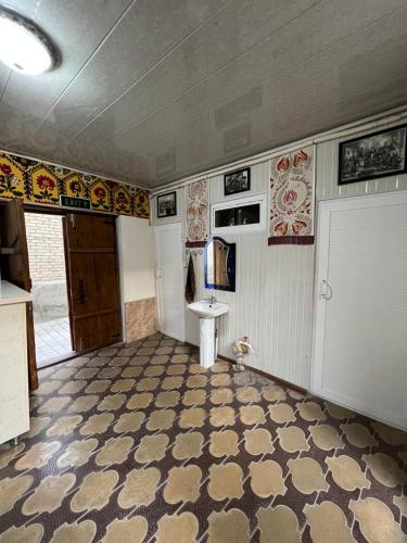 een lege kamer met een wastafel en een deur bij ''NAVO'' Guest House in Bukhara