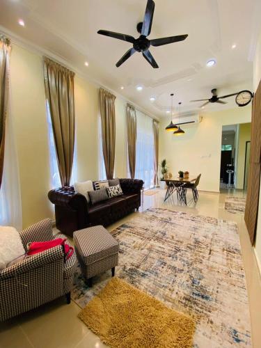 a living room with a couch and a ceiling fan at THE PINE HOUSE in Kuala Berang