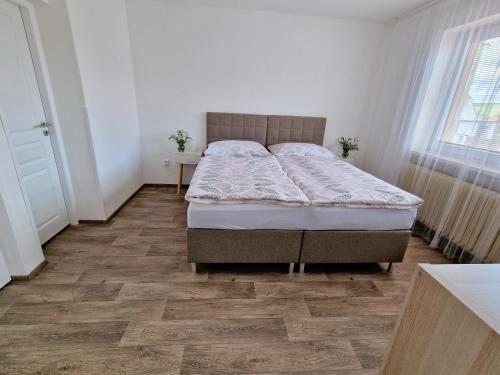a bedroom with a bed and a wooden floor at Čejkovský dvorek in Čejkovice