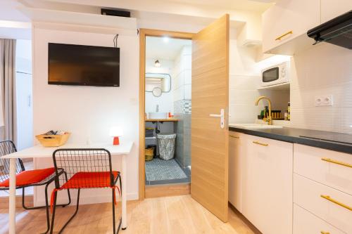 a kitchen with a table and a chair and a table and a kitchen with at Appartement cocooning proche mer in Carqueiranne