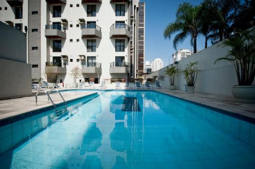 a swimming pool in front of a building at Apartamento Triplex Place Vendome in São Paulo