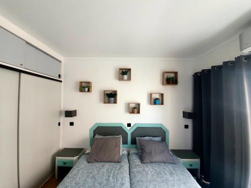 a bedroom with a blue bed and pictures on the wall at Santos LODGE surf - 5 minutes walking to Praia da Rocha in Portimão