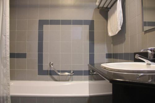 a bathroom with a sink and a bath tub and a sink at The Maple Suite in Kuala Lumpur