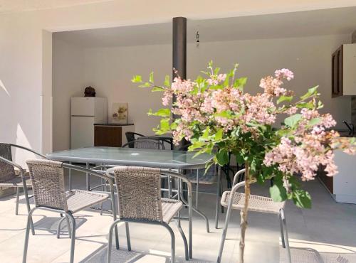 a dining room with a table and chairs with pink flowers at Čejkovský dvorek in Čejkovice