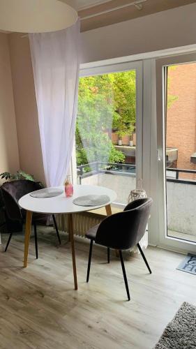 sala de estar con mesa, sillas y ventana en Apartment im Herzen von Bad Salzuflen am Kurpark, en Bad Salzuflen