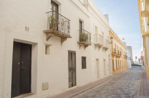 una calle vacía con edificios blancos y macetas en Apartamentos Tarifa Castillo, en Tarifa