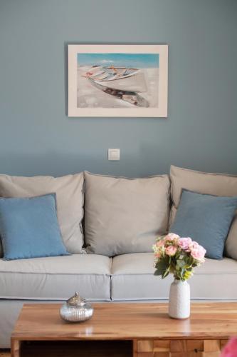 a living room with a couch with pillows and a table at chris apartement in Nydri