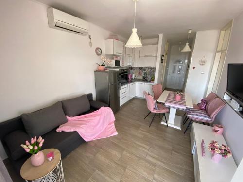 a living room with a couch and a kitchen at Golden View Penthouse in Zadar