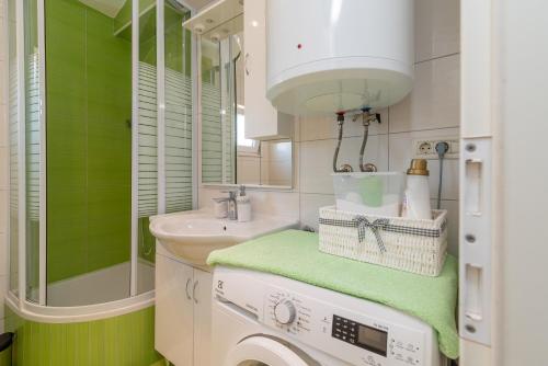 a bathroom with a washing machine and a sink at Apartment Roko in Trogir