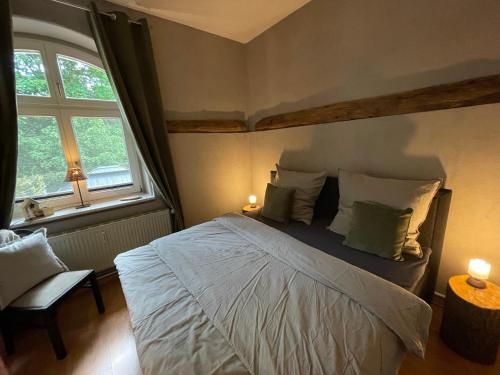 a bedroom with a large bed and a window at Bergrauschen - Waldbude in Goslar
