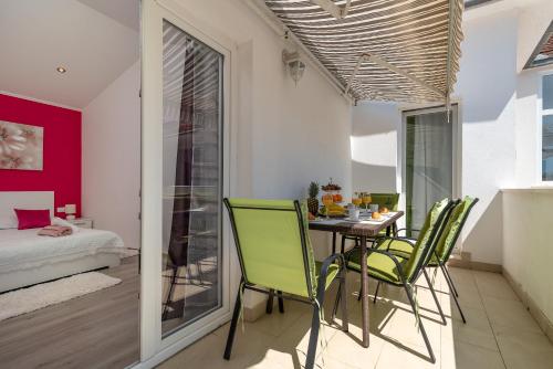 a dining room with a table and green chairs at Apartment Roko in Trogir