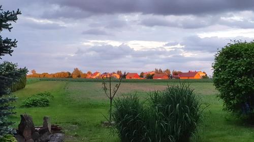 a field of grass with houses in the background at ZŁOTA PASIEKA Zator Przeciszów in Przeciszów