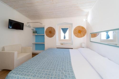 a white bedroom with a bed and a chair at B&B Gallipoli Vecchia in Gallipoli