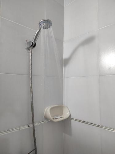 y baño de azulejos blancos con ducha. en Aeropuerto Internacional 1 de Ezeiza Nuestro lugar a 15 minutos del aeropuerto opcional tranfer en Ezeiza