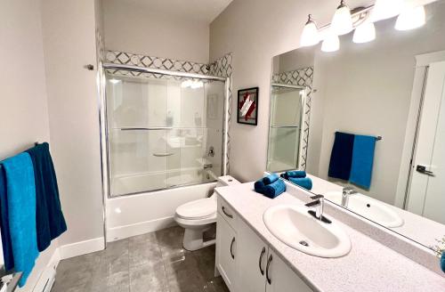 a bathroom with a sink and a toilet and a shower at Kelowna new lake view 2bedrooms suite close BIG WHITE in Kelowna