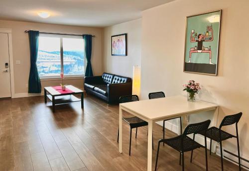 a living room with a table and chairs and a couch at Kelowna new lake view 2bedrooms close BIG WHITE in Kelowna