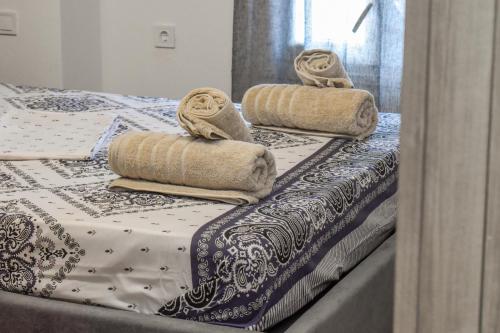 three towels are sitting on top of two beds at Klaidis house 2 floor in Skiathos Town