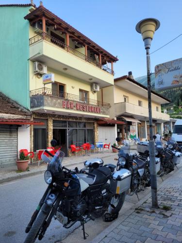 una fila de motocicletas estacionadas frente a un edificio en Nako Guest House bar&restaurants, en Përmet