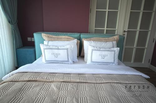 a bed with white pillows and a blue head board at Ferush Boutique Hotel in Urla