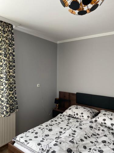 a bedroom with a bed with a black and white comforter at Csengődi Csecske Panzió in Csengőd