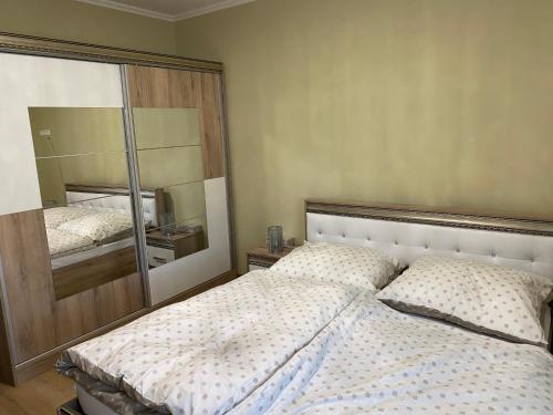 sypialnia z łóżkiem i dużym lustrem w obiekcie Csengődi Csecske Panzió w mieście Csengőd
