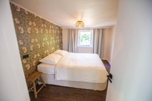 a bedroom with a white bed and a window at Boshuisje op de Veluwe in Nunspeet