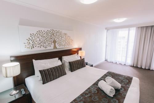 a bedroom with a large bed and a large window at Newcastle Central Plaza Apartment Hotel in Newcastle