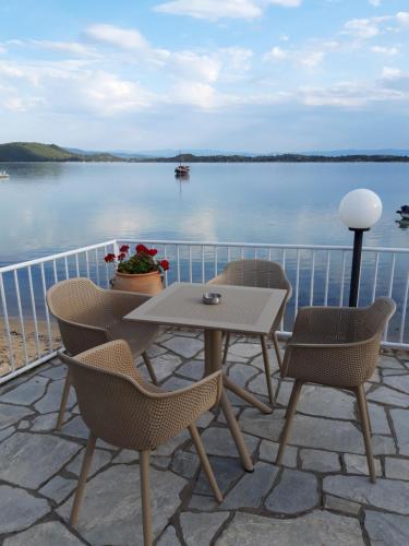 a table and chairs on a patio with a view of the water at Vourvourou Hotel in Vourvourou