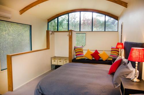 a bedroom with a large bed with colorful pillows at Ashwood Cottages in Bright