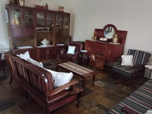 sala de estar con muebles de madera y mesa en Waboom Farm Stay, en Swartruggens