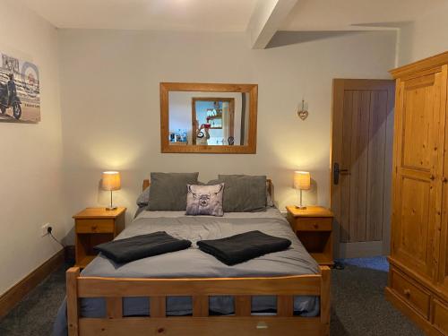 ein Schlafzimmer mit einem Bett mit zwei Lampen und einem Spiegel in der Unterkunft Masons Nook 292 Mansfield Road NG174HR in Skegby