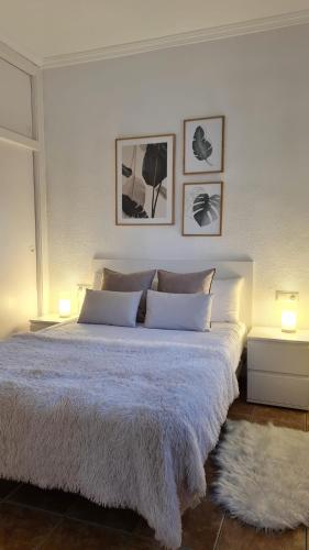 a bedroom with a large white bed with two lamps at La Voreta in Villajoyosa