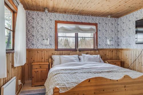 um quarto com uma cama num quarto de madeira em Guesthouse on an Island em Dekarsön