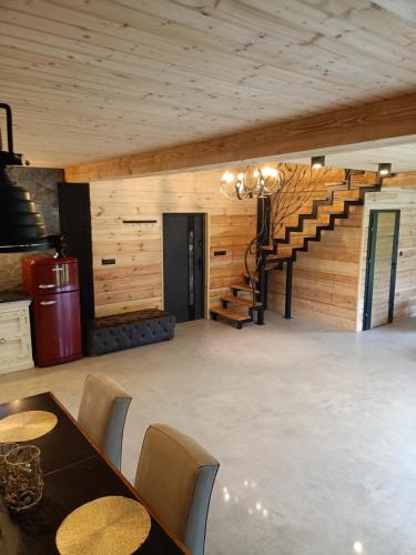 a dining room with a table and a staircase at Agroturystyka Podlasie dom nad stawem in Dobrzyniewo Duże