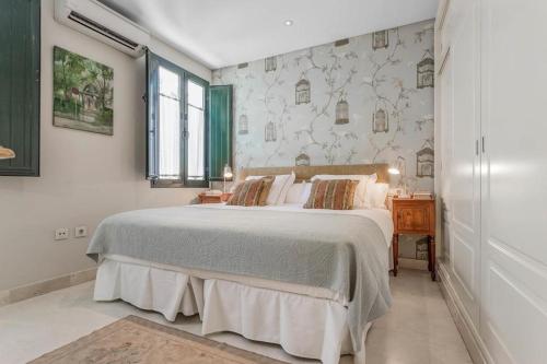 una camera da letto con un letto grande e una finestra di FAM Sevillian Townhouse a Siviglia
