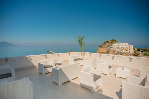 a view of a balcony with white chairs and the ocean at Naro Suites and Rooms in Bacoli