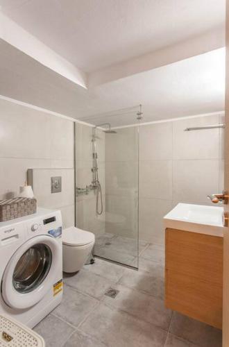 a bathroom with a washing machine and a toilet at Neoria apartment in Chania