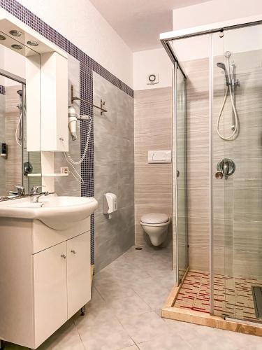 a bathroom with a shower and a sink and a toilet at Hotel Majestic in Durrës