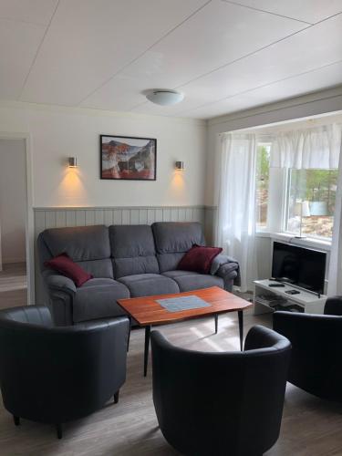 uma sala de estar com um sofá e uma mesa em Hede, stuga em Hede