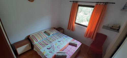 um pequeno quarto com uma cama e uma janela em Apartment More em Tučepi